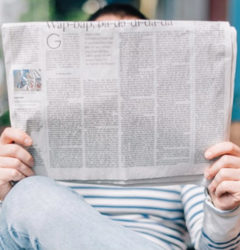 person sitting checking newspaper