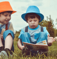 male kids reading a book together