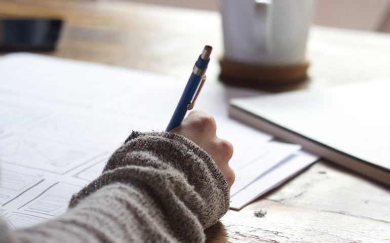 woman holding pen writing