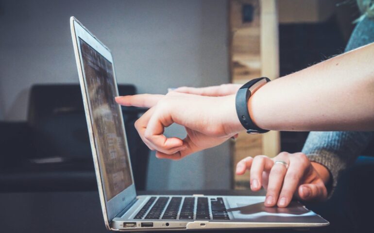 hands pointing to laptop