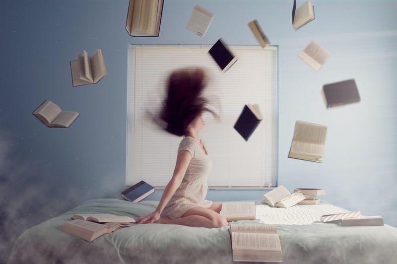 lady on the bed with books